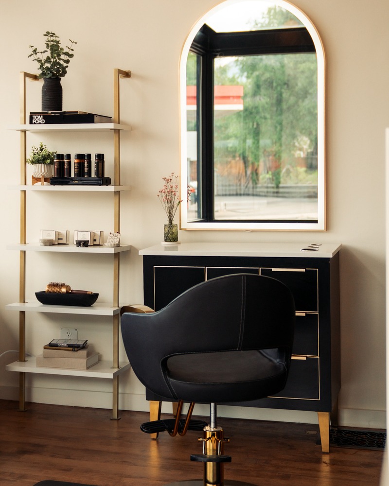 A styling chair before an arched mirror where precision haircuts are designed at Rise Above Beauty Lounge in Colorado Springs